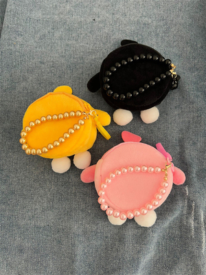 Une pièce de monnaie en peluche un sac à main un pendentif un écouteur un sac à main